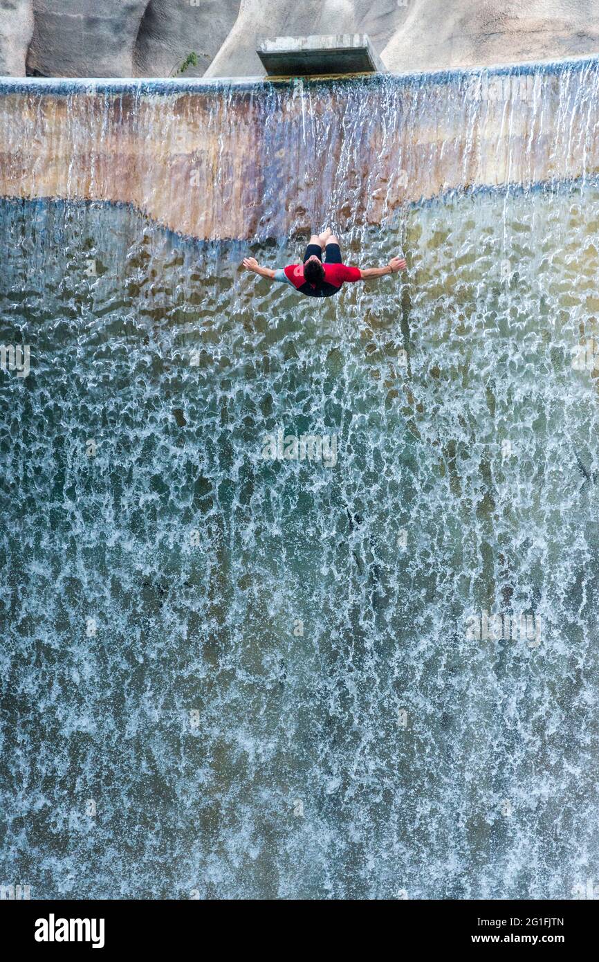 Person, die rückwärts vom Victoria Wasserfall im kanadischen Wunderland abtaucht. Die Wasserfälle erscheinen wie riesige Vorhänge auf dem Wunderberg. Ca Stockfoto