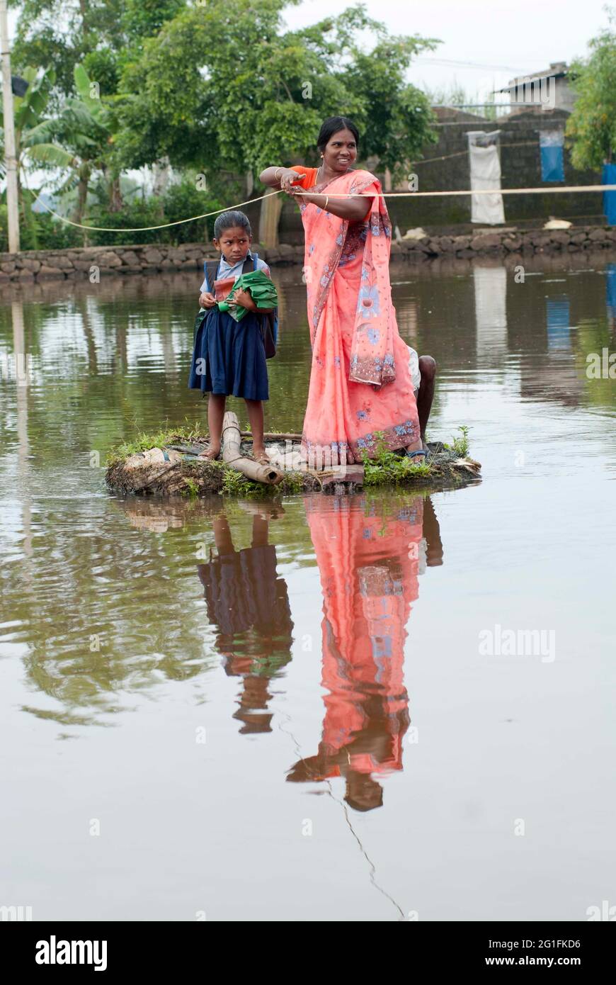 Eine Frau und ein Schulmädchen überqueren die Backwaters mit Hilfe des Seils und ein Land, das in die Schwebe gesetzt wurde, Kerala, Indien Stockfoto