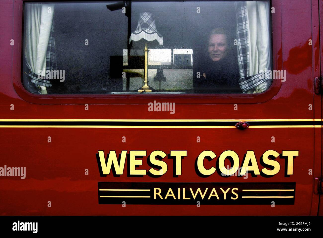 West Coast Express, 1. Klasse, Passagier, Frau, die aus dem Fenster schaut, Jacobite Express, Dampflokomotive, Eisenbahn, Zug, West Highland Line Stockfoto