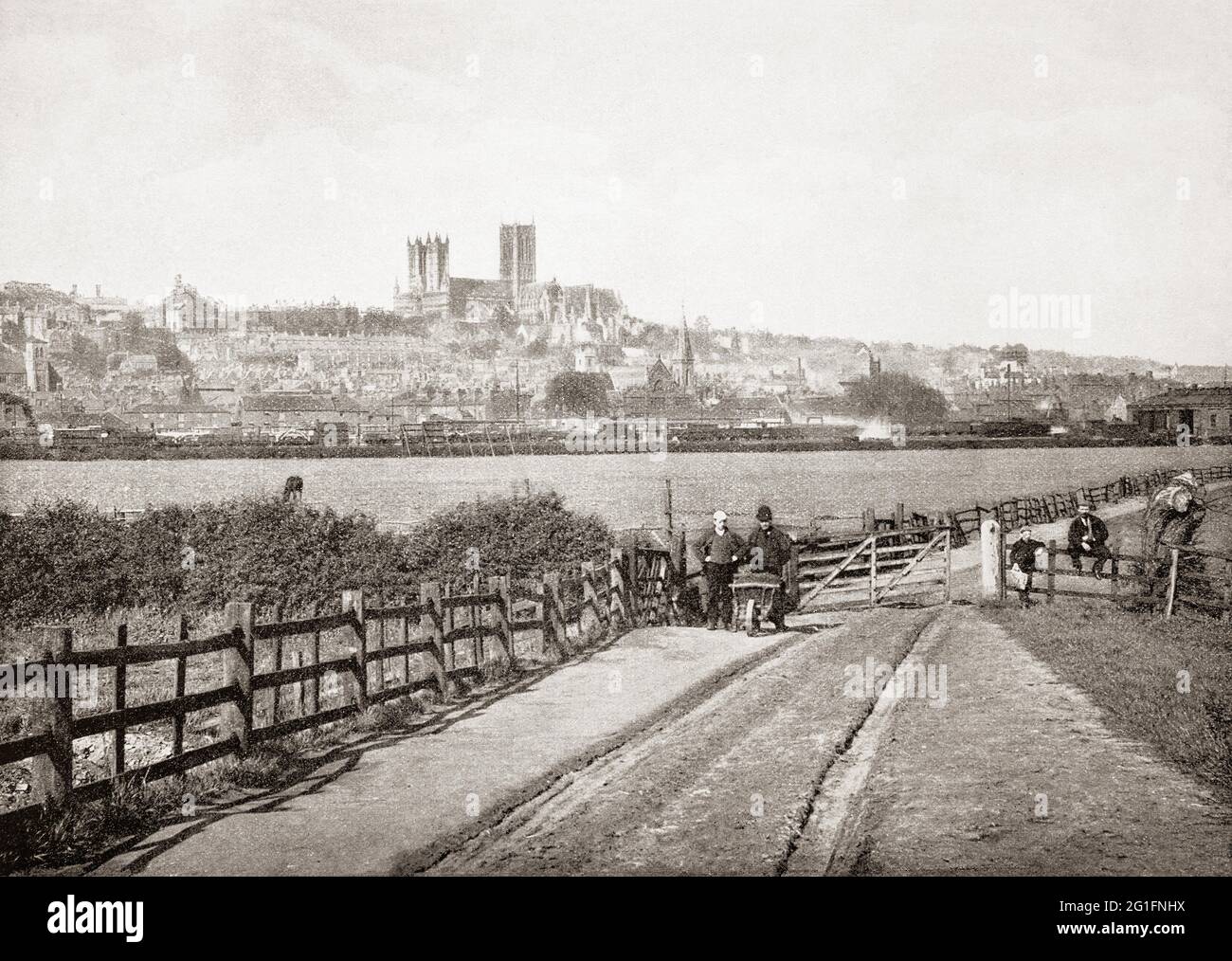 Eine Ansicht der Landarbeiter aus dem späten 19. Jahrhundert auf den Feldern in der Nähe von Lincoln, einer Domstadt und Grafschaft-Stadt von Lincolnshire in den East Midlands von England. In der Römerzeit Lindum Colonia genannt, entwickelte sie sich aus einer eisenzeitlichen Siedlung am Fluss Witham. Die englisch-gotische Lincoln Cathedral, einst das höchste Gebäude der Welt seit über 200 Jahren, thront über der Stadt. Stockfoto