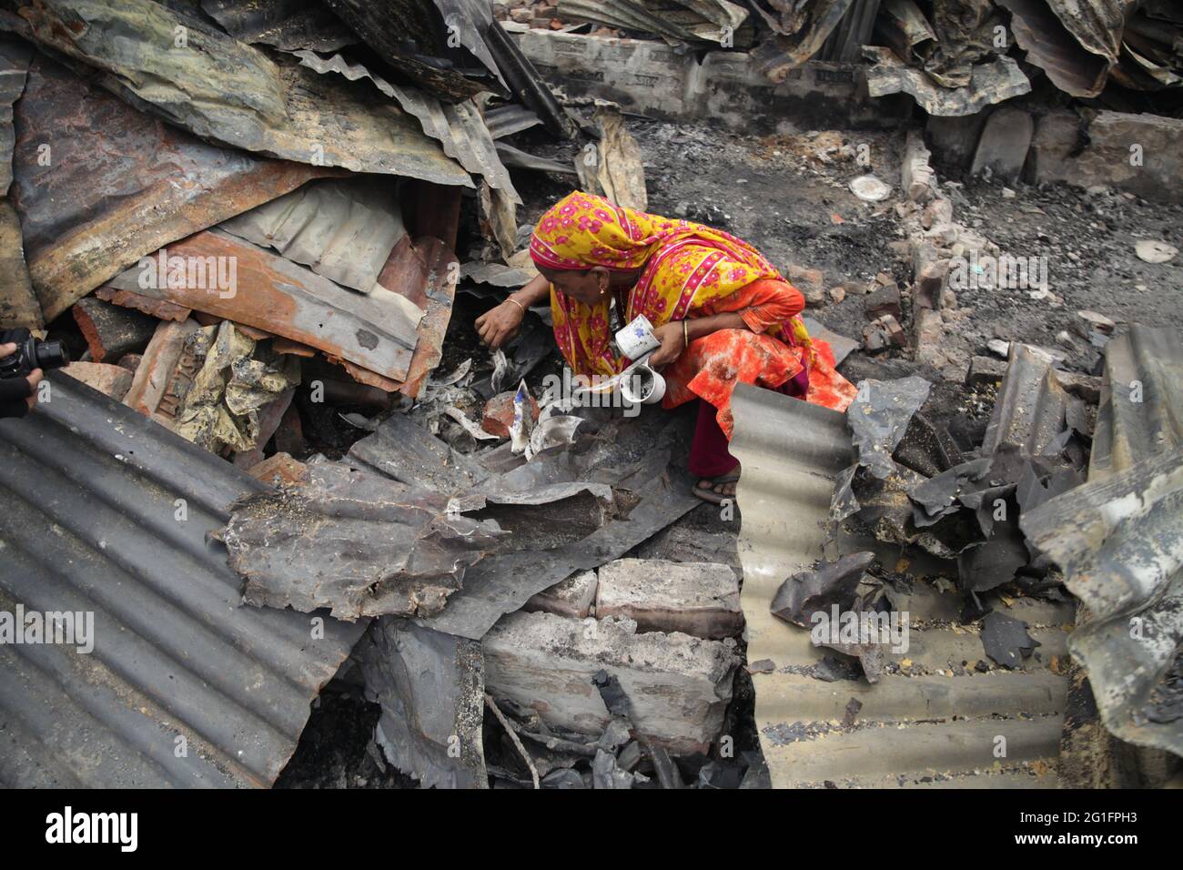 Jun 07 2021.Dhaka, Bangladesch. Nachdem sie das Feuer auslöschen, suchen zwei Frauen in ihrem Haus nach den notwendigen Gegenständen. Stockfoto