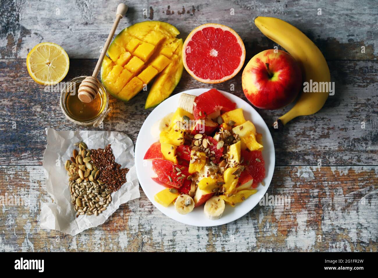 Super frischer, nahrhafter Obstsalat mit Samen. Salat mit Mango, Banane und Grapefruit. Vitaminfutter. Gesunde Ernährung. Stockfoto