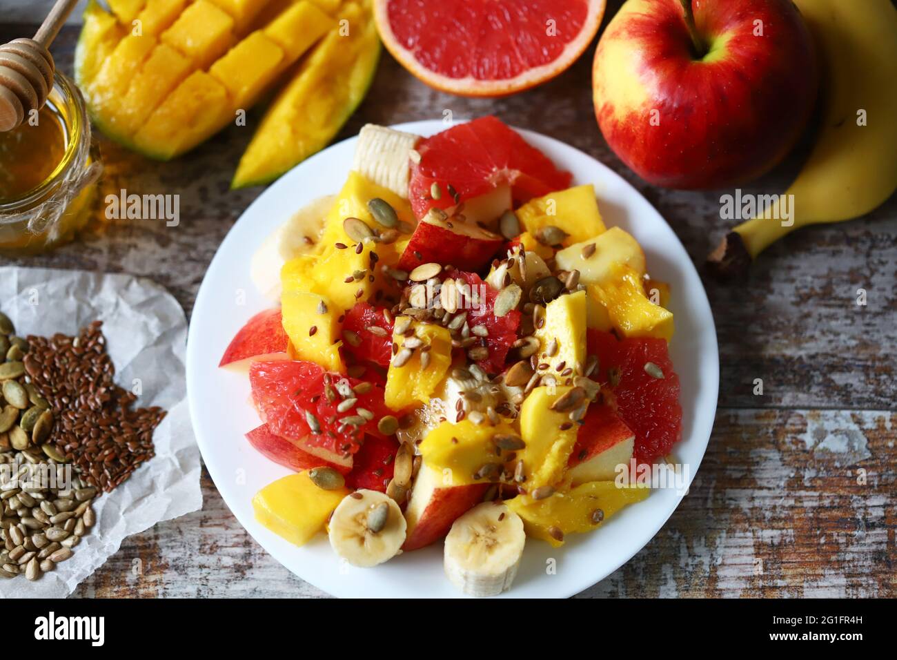 Super frischer, nahrhafter Obstsalat mit Samen. Salat mit Mango, Banane und Grapefruit. Vitaminfutter. Gesunde Ernährung. Stockfoto