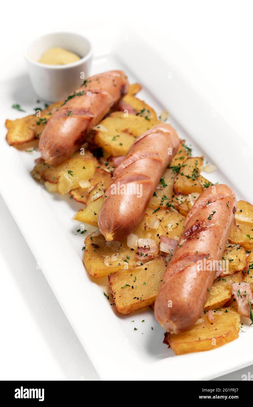 deutsche Bio-Käse- und Schweinefleischwürste mit gebratener Kartoffel und Senf auf weißem Hintergrund Stockfoto