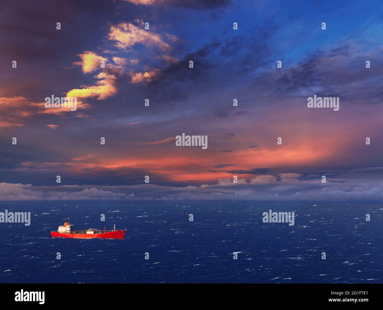 Rotes Schiff im Meer bei Sonnenuntergang Stockfoto