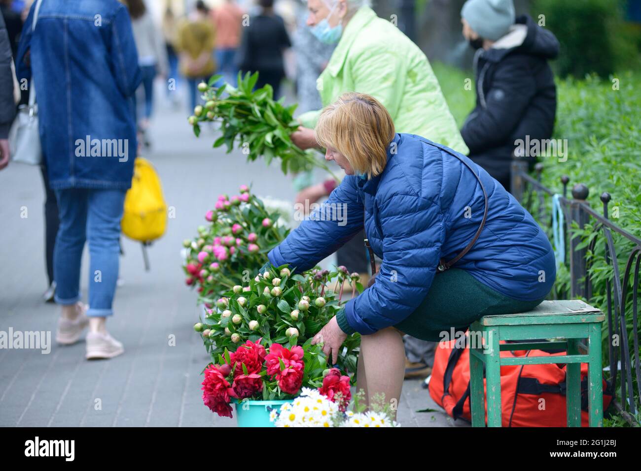 Alte Blumenhändler verkaufen Blumen auf der Straße der Stadt Stockfoto