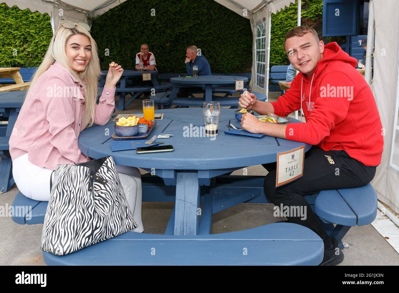 Cork, Irland. Juni 2021. Murphys Rock Bar and Restaurant wird wiedereröffnet, Cork, Irland. Abgebildet (LToR) sind Ciara Bruton und Alan Shehan (beide Faranree), die ihr Mittagessen und einen Drink in der Murphys Rock Bar und Restaurant genießen. Murphys Rock Bar and Restaurant wurde heute um 12 Uhr wegen der Covid-19-Pandemie zum ersten Mal in diesem Jahr für Sitzbesetzungen wiedereröffnet. Die Bar, die einen Take-away-Service betrieben hatte, ist jetzt für die Öffentlichkeit geöffnet, um sich im Freien zu setzen und die Bars zu genießen, die viele Einheimische während der Pandemie verpasst haben. Kredit: Damian Coleman/Alamy Live Nachrichten Stockfoto