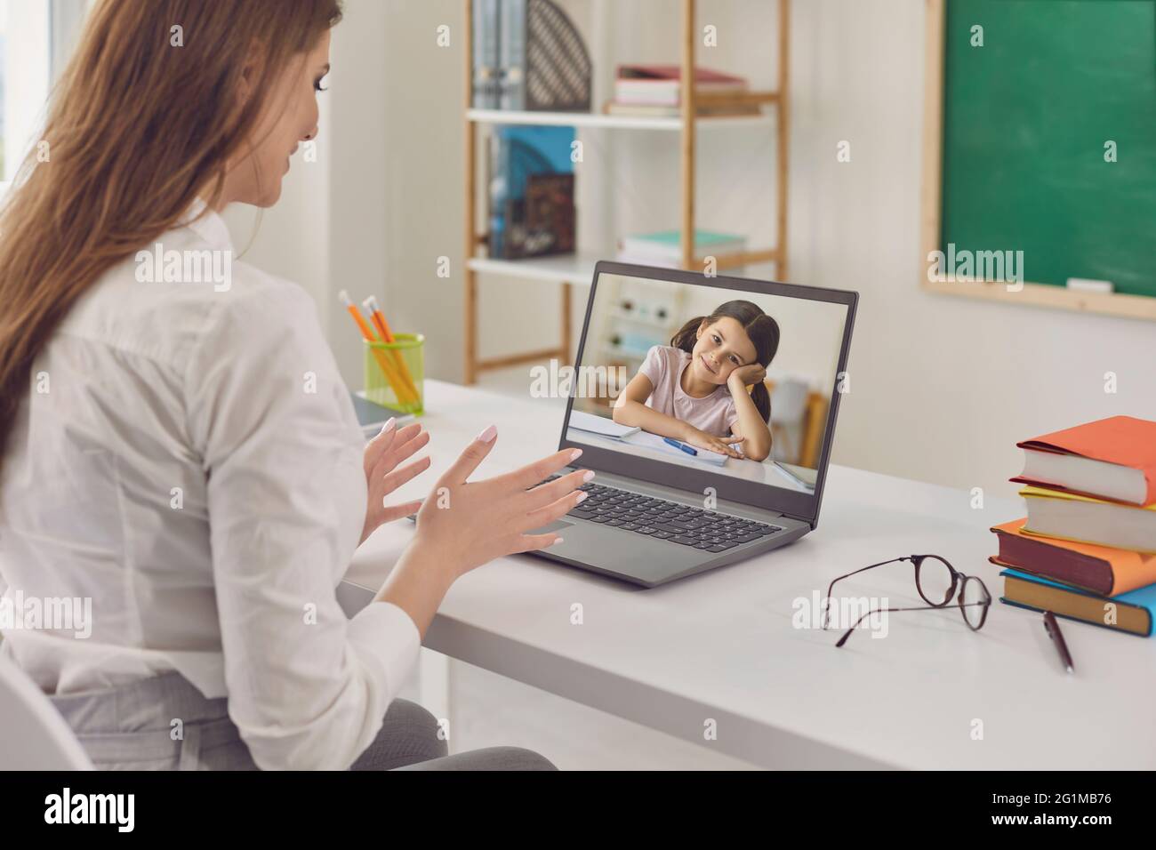 Online-Kindererziehung. Eine Lehrerin unterrichtet ein Schulmädchen mithilfe einer virtuellen Schule Web-Chat-Anwendung. Stockfoto
