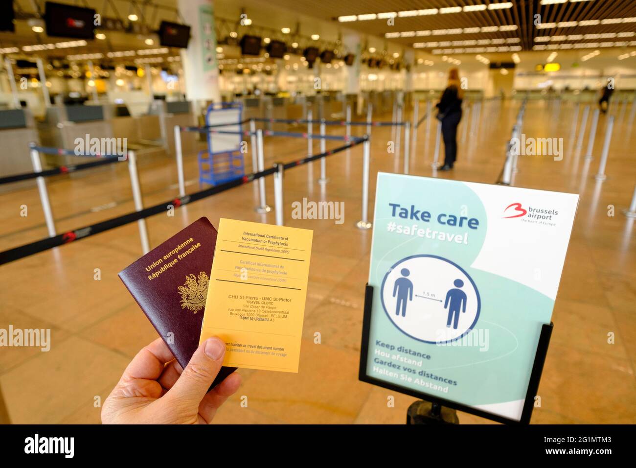 Belgien, Brüssel, Flughafen Zaventem, 26. Februar 2021: Französischer Reisender mit seinem Reisepass und einem Internationalen Impfzertifikat oder Prophylax Stockfoto