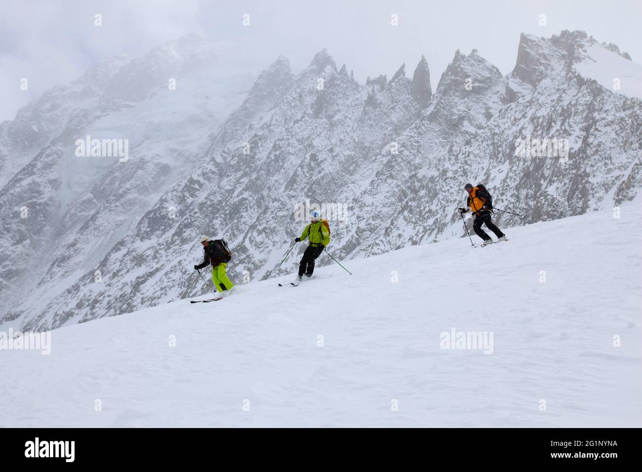 Frankreich, Haute-Savoie, Chamonix-Mont-Blanc, Mont-Blanc-Massiv, drei Bergsteiger, die im Nebel Ski fahren, bei den Grands Montets (3295 m) Stockfoto