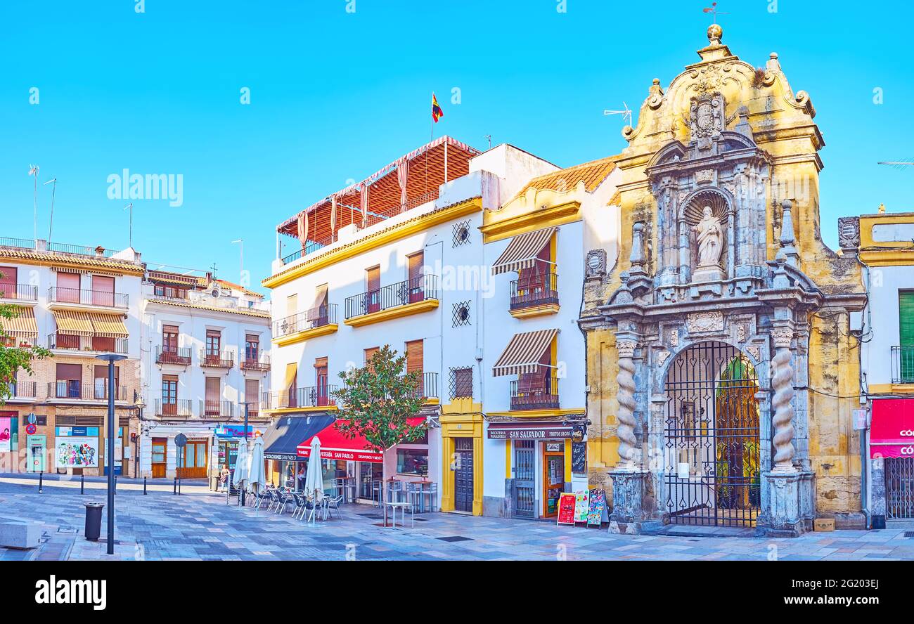 CORDOBA, SPANIEN - SEP 30, 2019: Panorama der Straße Calle Capitulares mit Restaurants, historischen Gebäuden und kunstvoll geschnitztem Steintor von San Pablo Chu Stockfoto
