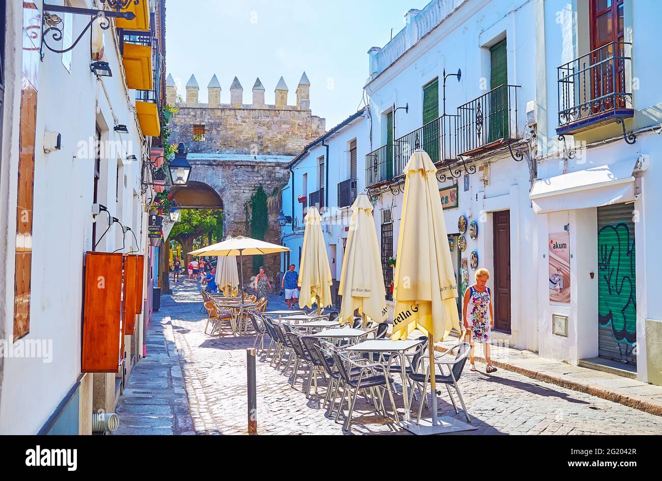 CORDOBA, SPANIEN - SEP 30, 2019: Das alte Cordoba verfügt über das erhaltene steinerne Puerta de Almodovar-Tor, das hinter den Outdoor-Sonnenschirmen des Restaurants am 30. September zu sehen ist Stockfoto