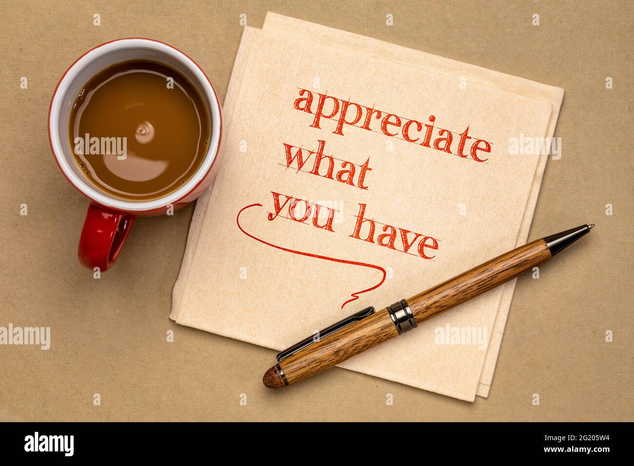 Schätzen Sie, was Sie haben - inspirierende Worte auf einer Serviette mit einer Tasse Kaffee, Positivität und persönlicher Entwicklung Stockfoto
