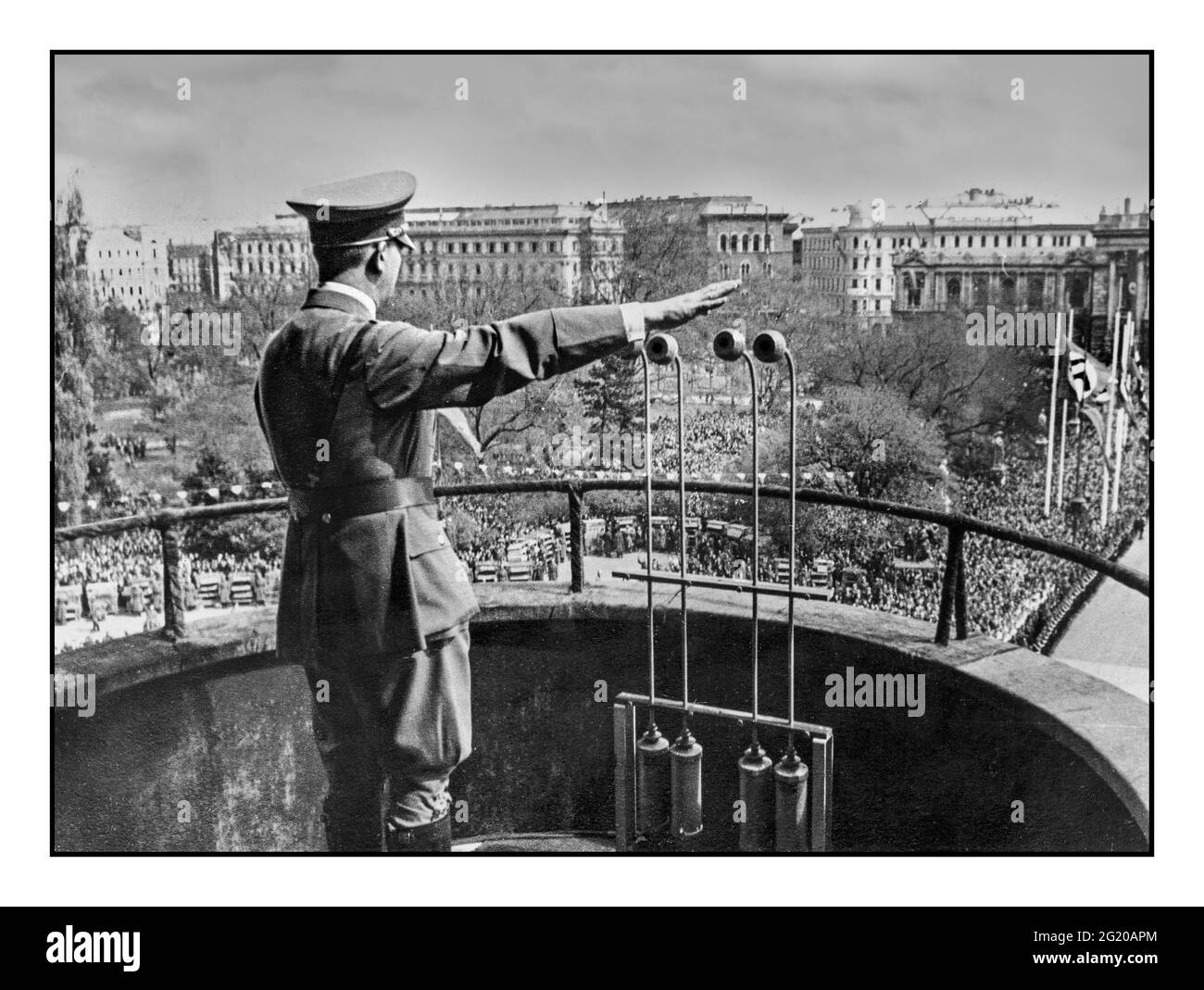 ANSCHLUSS ADOLF HITLER GRUSS IN WIEN ÖSTERREICH NACH ANSCHLUSS 15. MÄRZ 1938 spricht Adolf Hitler in Uniform vom Balkon des Wiener Rathauses mit Hilfe von Rundfunkmikrofonen am 15. März 1938 in Wien an. Am 12. März 1938 erfolgte die Besetzung durch die NS-Annexion Stockfoto