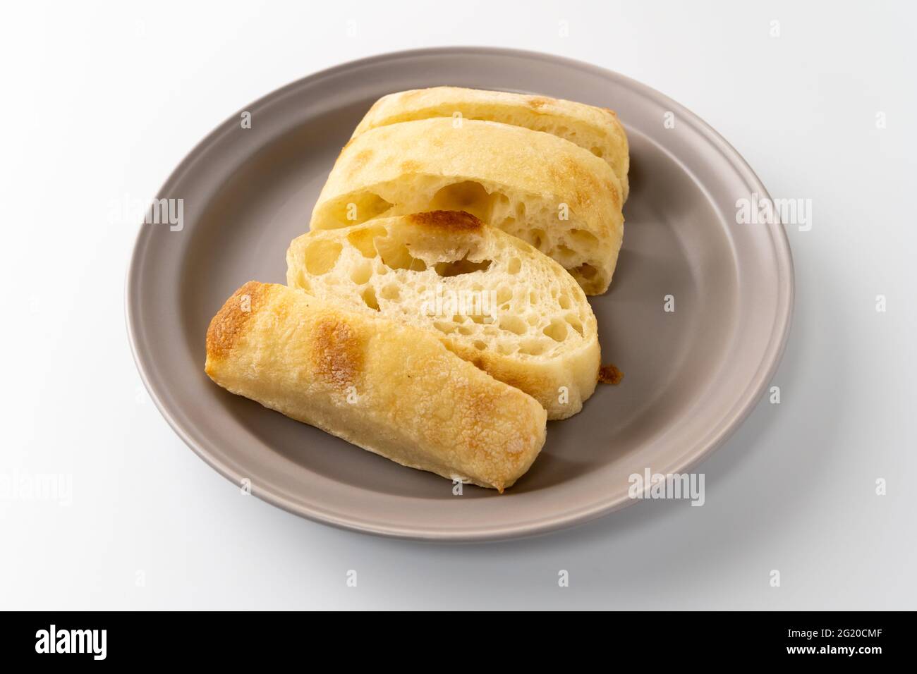 Frisch gebackenes Ciabatta-Brot wird auf einen Teller gelegt Stockfoto