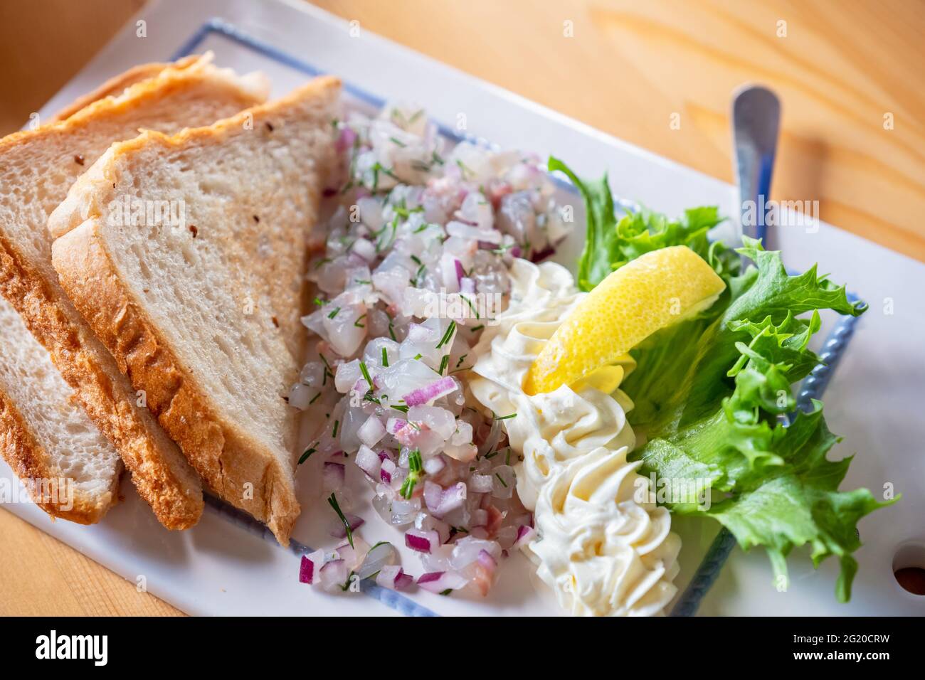 Zander-Tartare mit Zwiebel und Brottoast Stockfoto