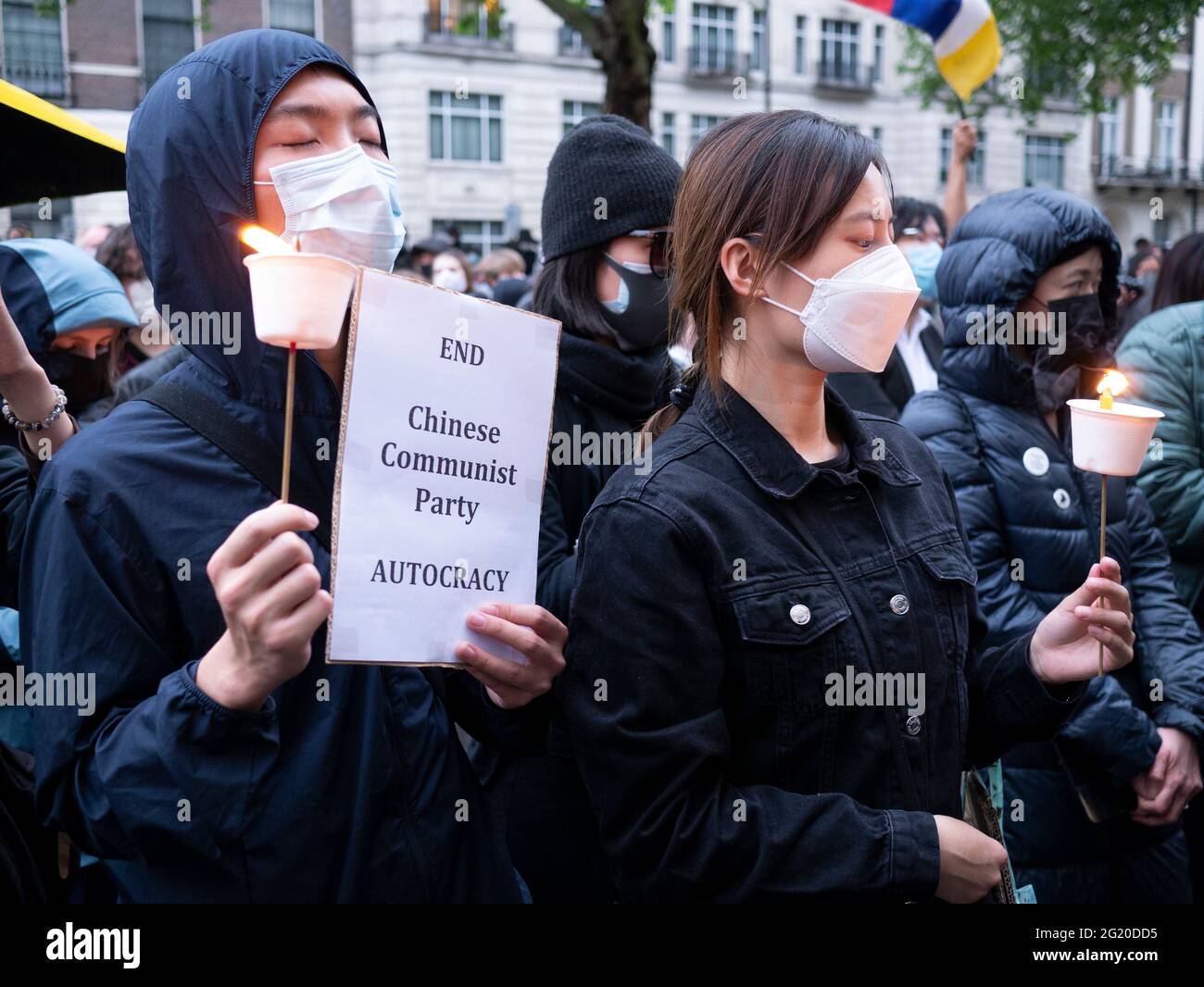 Maskierte Demonstranten versammeln sich mit Kerzen vor der chinesischen Botschaft in London, Großbritannien, zum 32. Jahrestag des Massakers vom 4. Juni auf dem Platz des Himmlischen Friedens in China. Stockfoto