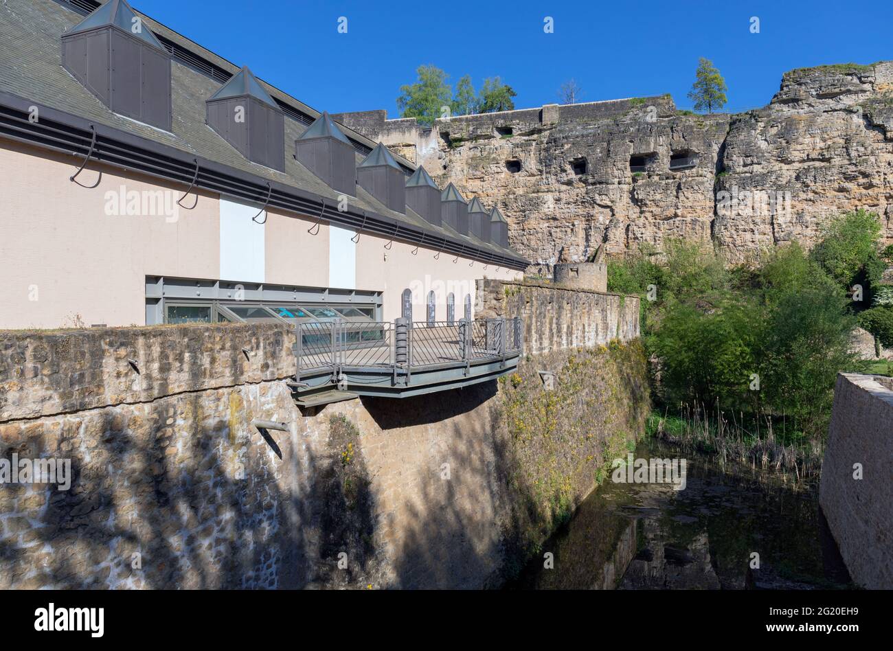 Europa, Luxemburg, Luxemburg-Stadt, Salle Robert Krieps (Theater) in der Nähe der Alzette mit den Casemates du Bock Befestigungsanlagen dahinter Stockfoto