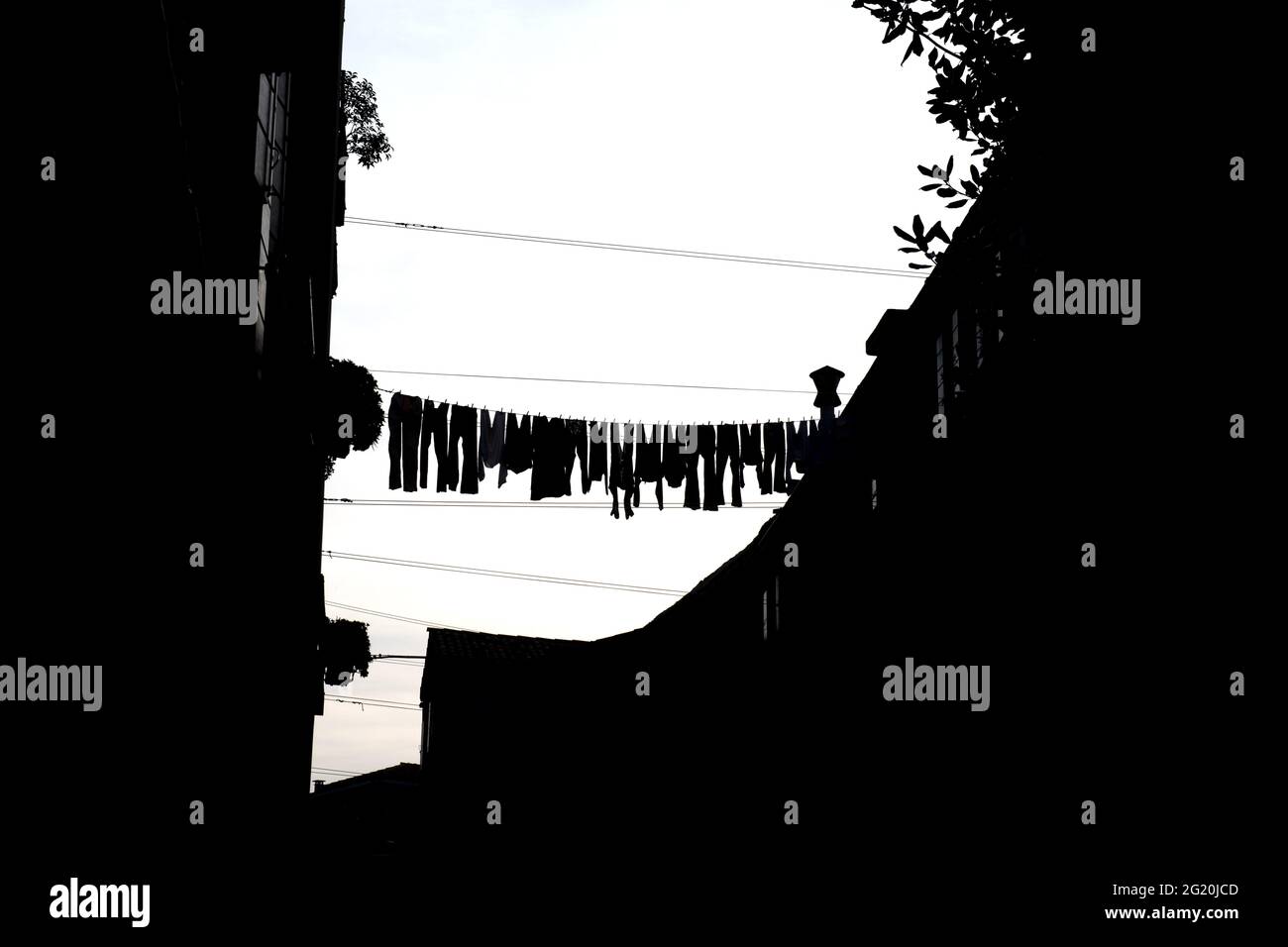 Über einer calle im Viertel Cannaregio in Venedig wurden Kleidungsstücke mit Silhouetten aufgehängt. Stockfoto