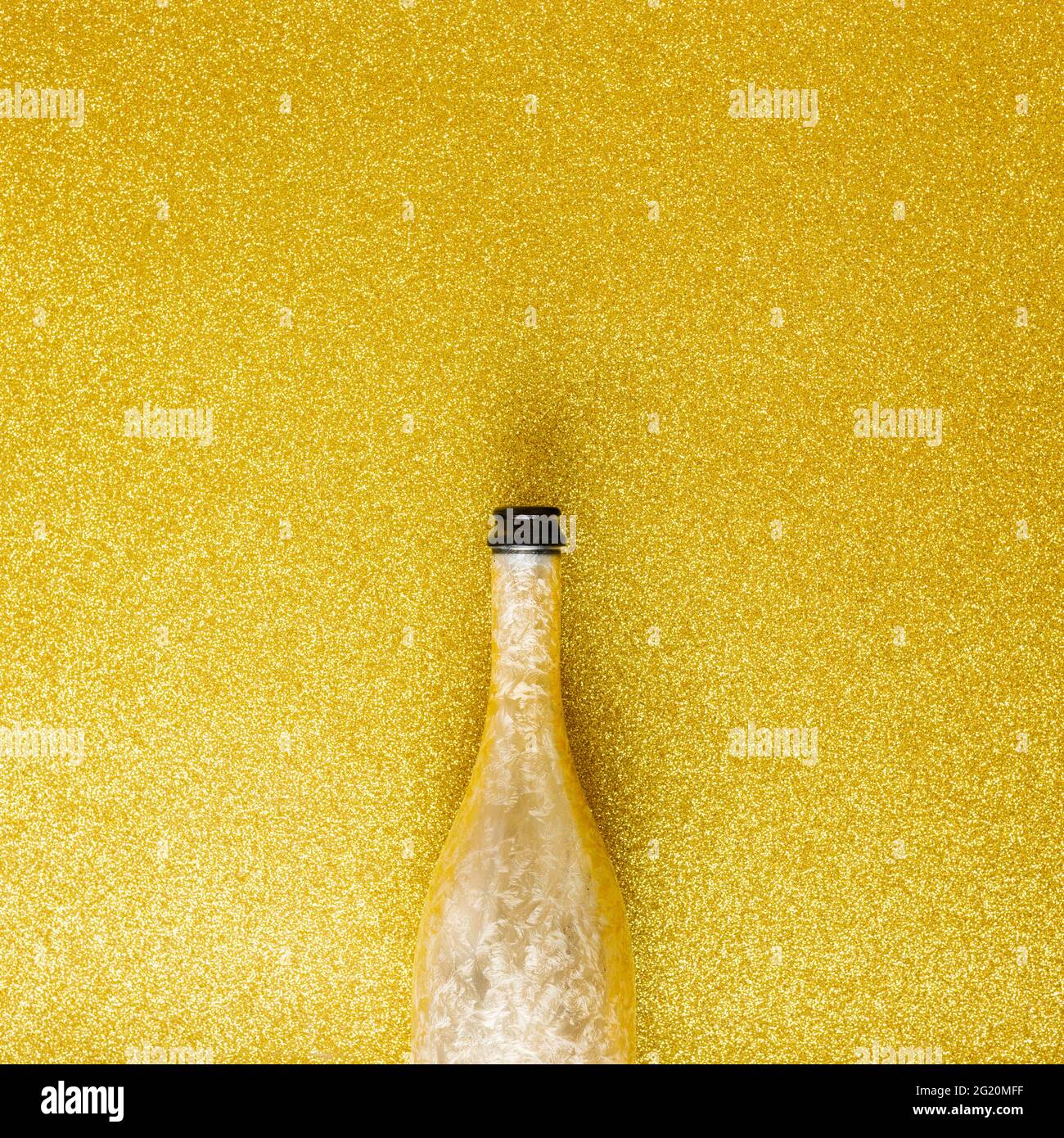 Champagnerflasche auf glänzendem goldenem Hintergrund, Minimal Party Drink Komposition, benutzerdefinierter Text Stockfoto