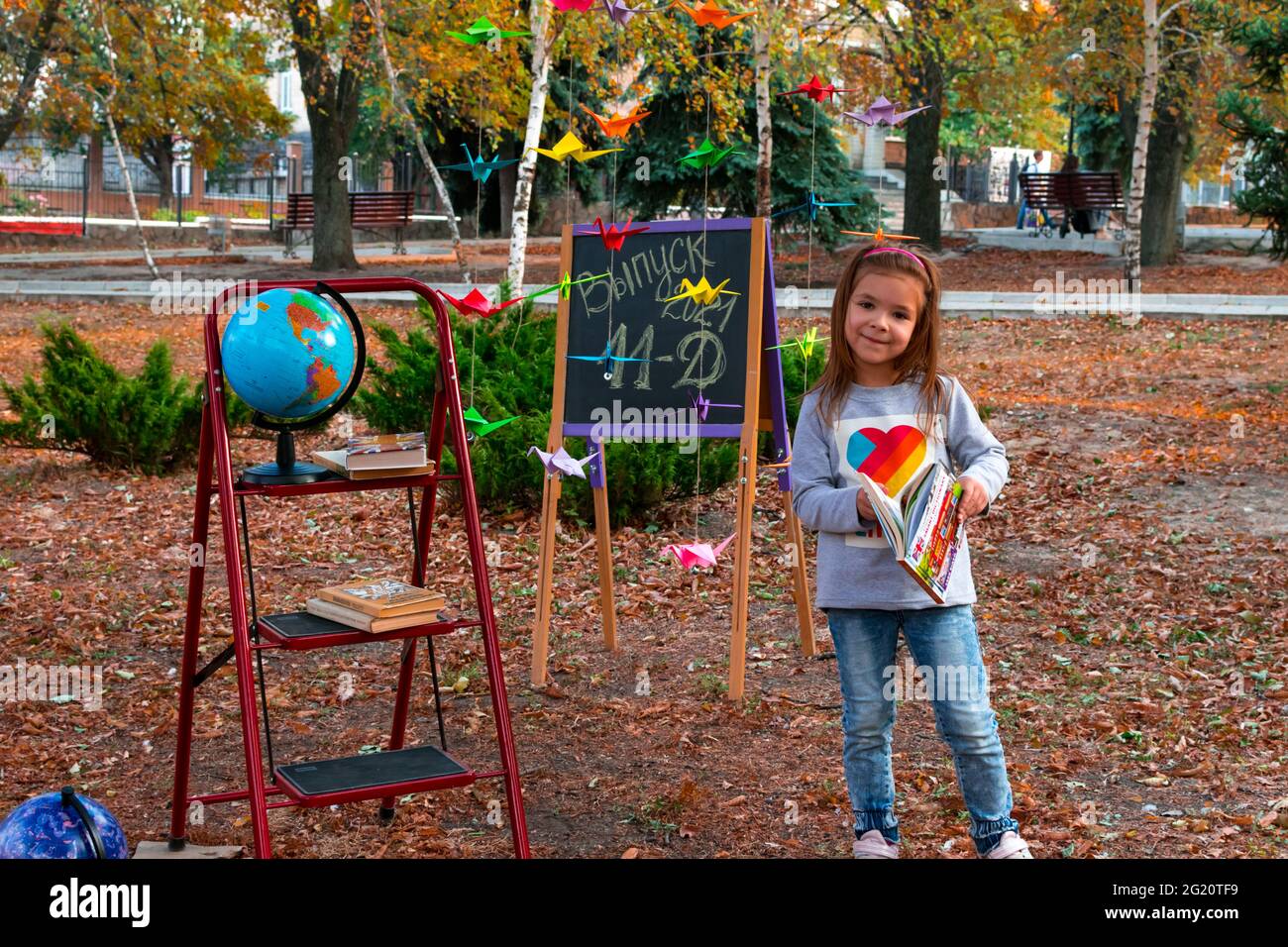 Lysytschansk. Ukraine 10.04.2020. Ausgabe 2021 11 D. bezauberndes Schulmädchen vor dem Hintergrund eines Herbstparks vor dem Hintergrund eines Stockfoto