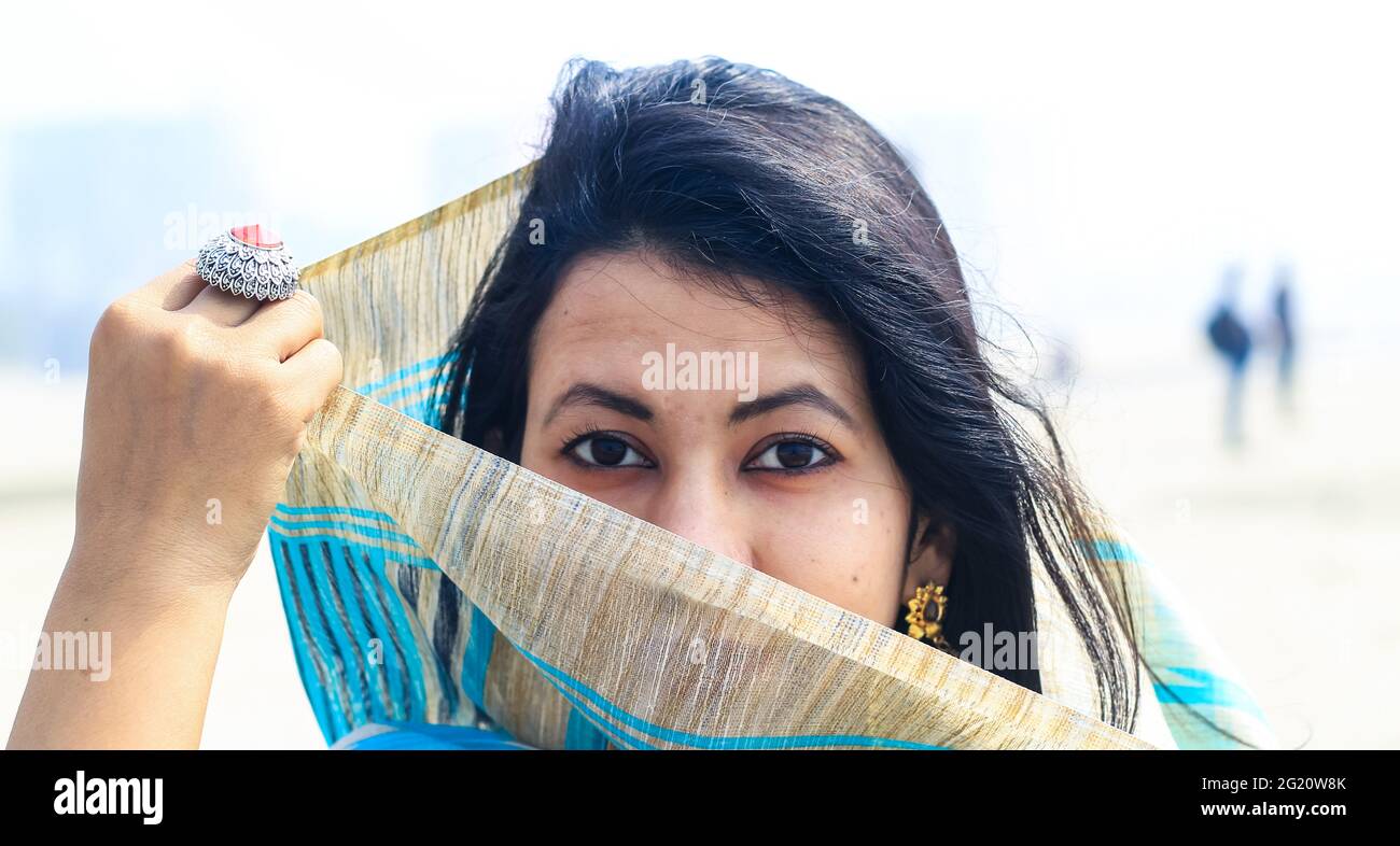 Junge Inderin Porträt in Sari mit ihrem Gesicht bedeckt. Die schöne indische muslimische Frau bedeckt ihr Gesicht mit Saree. Stockfoto