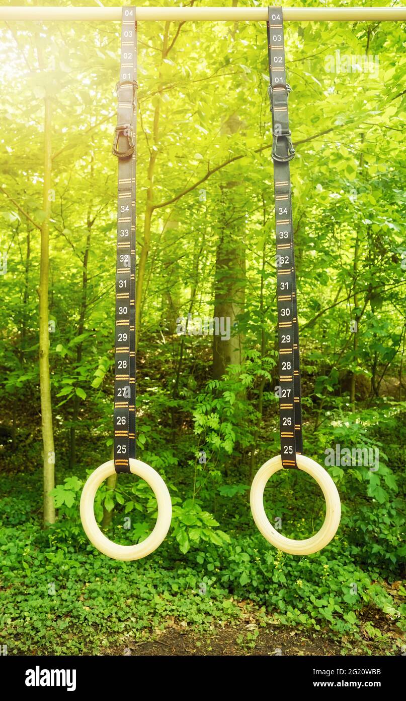 Turnringe mit nummerierten Riemen, die in einem Park hängen. Stockfoto