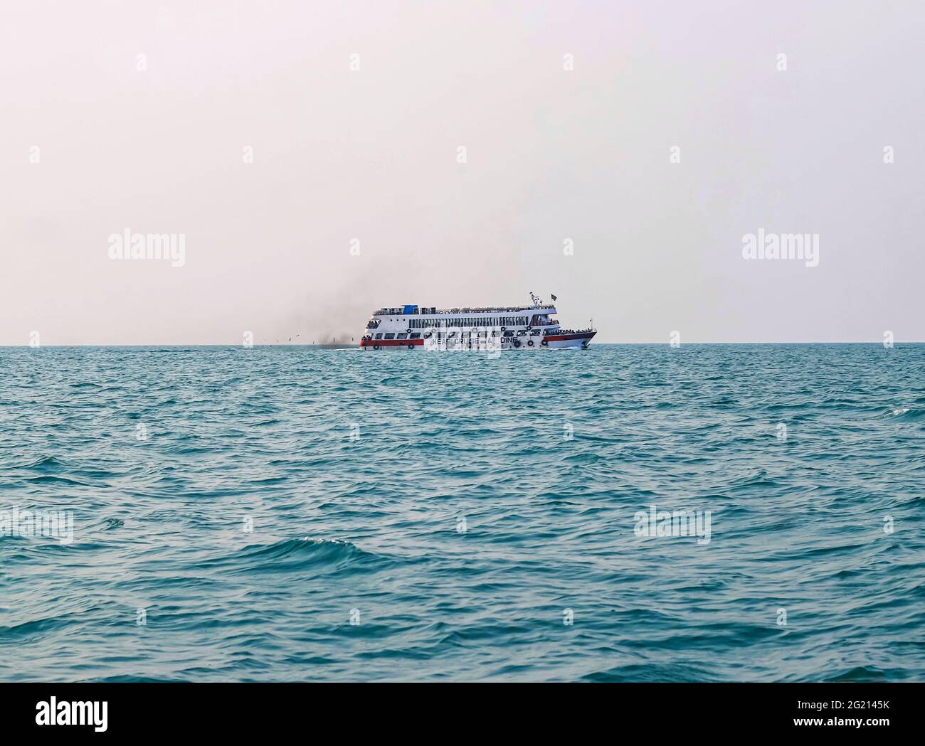 Das Fährschiff der Bucht von Bengalen raucht aus seinem Kamin. Schwarze Abgase, die nach der Zündung des Hauptmotors aus dem Kamin eines festgetäuten Tankers stammen. Stockfoto