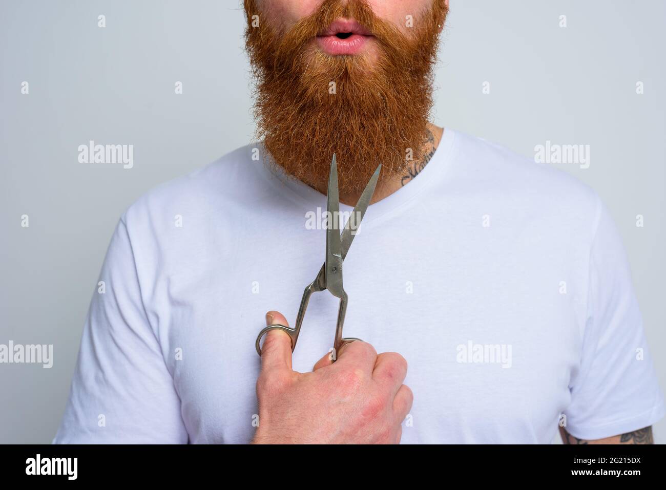 Wunderter Mann mit Schere ist bereit, den Bart zu schneiden Stockfoto