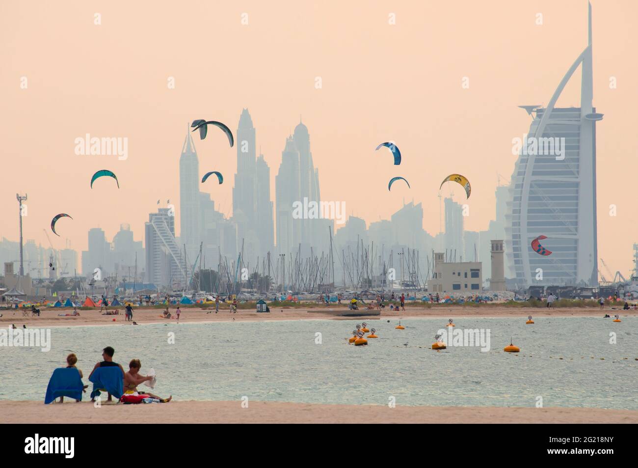 Skyline von Dubai mit Kitesurfern im Abendlicht Stockfoto