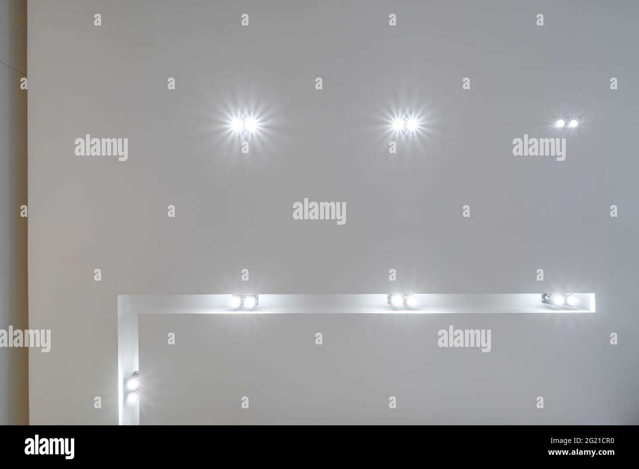 Abgehängte Decke mit LED-Dioden Spots Lampen und Trockenbau in leerem Raum in der Wohnung oder Haus. Stretch-Decke weiß und komplexe Form. Stockfoto