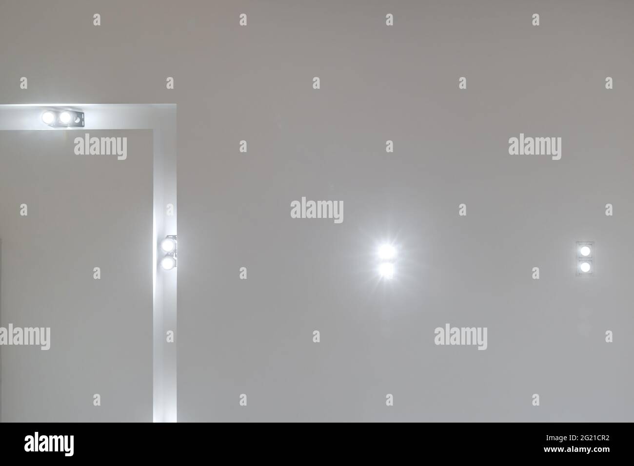 Abgehängte Decke mit LED-Dioden Spots Lampen und Trockenbau in leerem Raum in der Wohnung oder Haus. Stretch-Decke weiß und komplexe Form. Stockfoto