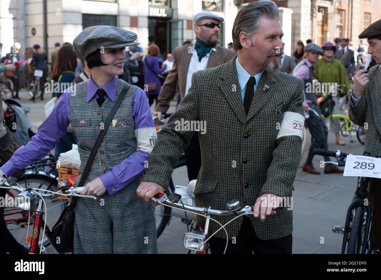 Ein Tweed-gekleidetes Paar posiert mit seinem Fahrrad beim London Tweed Run. Stockfoto Ein Tweed-gekleidetes Paar posiert mit seinem Fahrrad beim London Tweed Run. Stockfoto