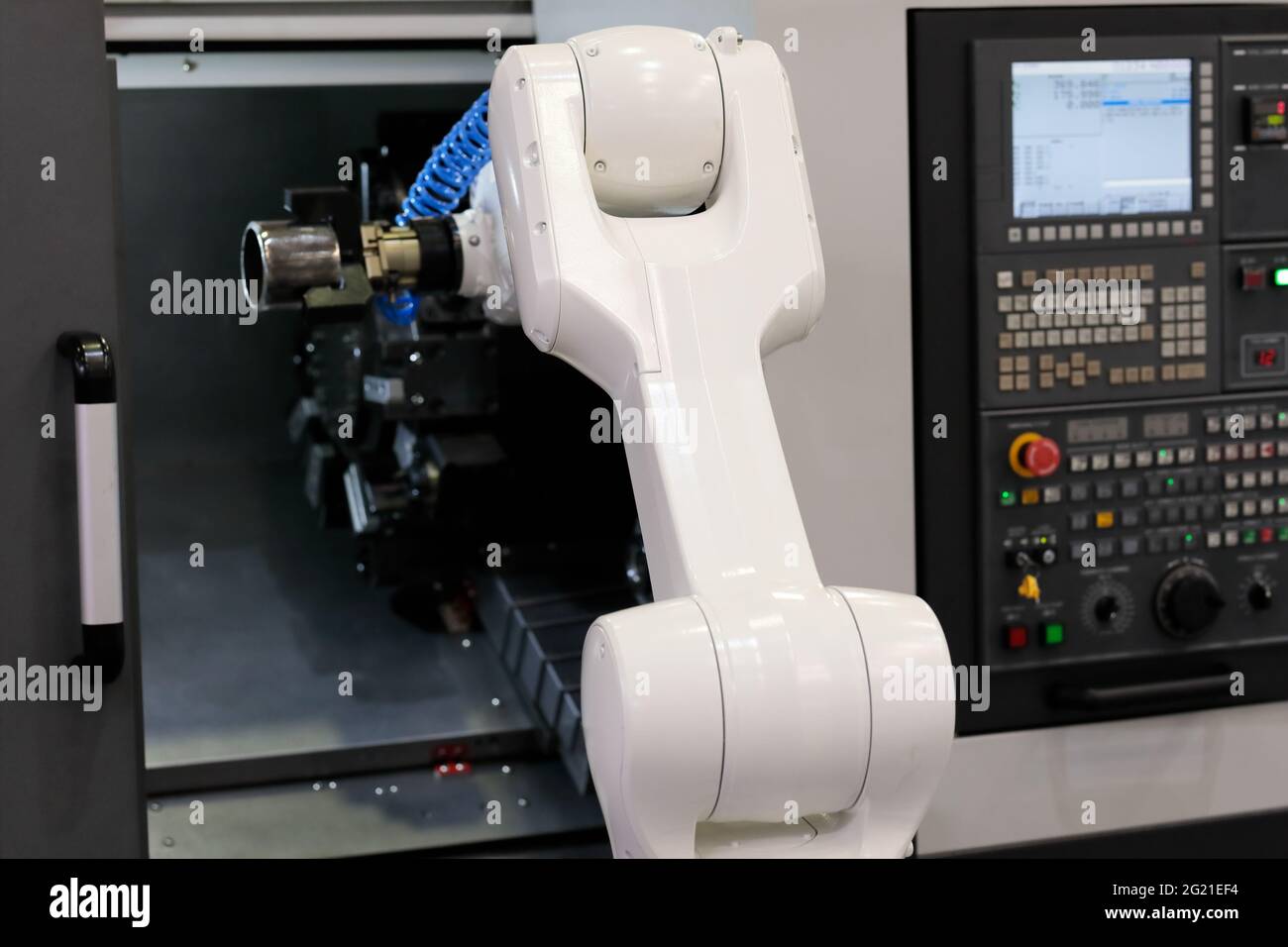 Roboter lädt das Werkstück in die CNC-Drehmaschine. Selektiver Fokus. Stockfoto