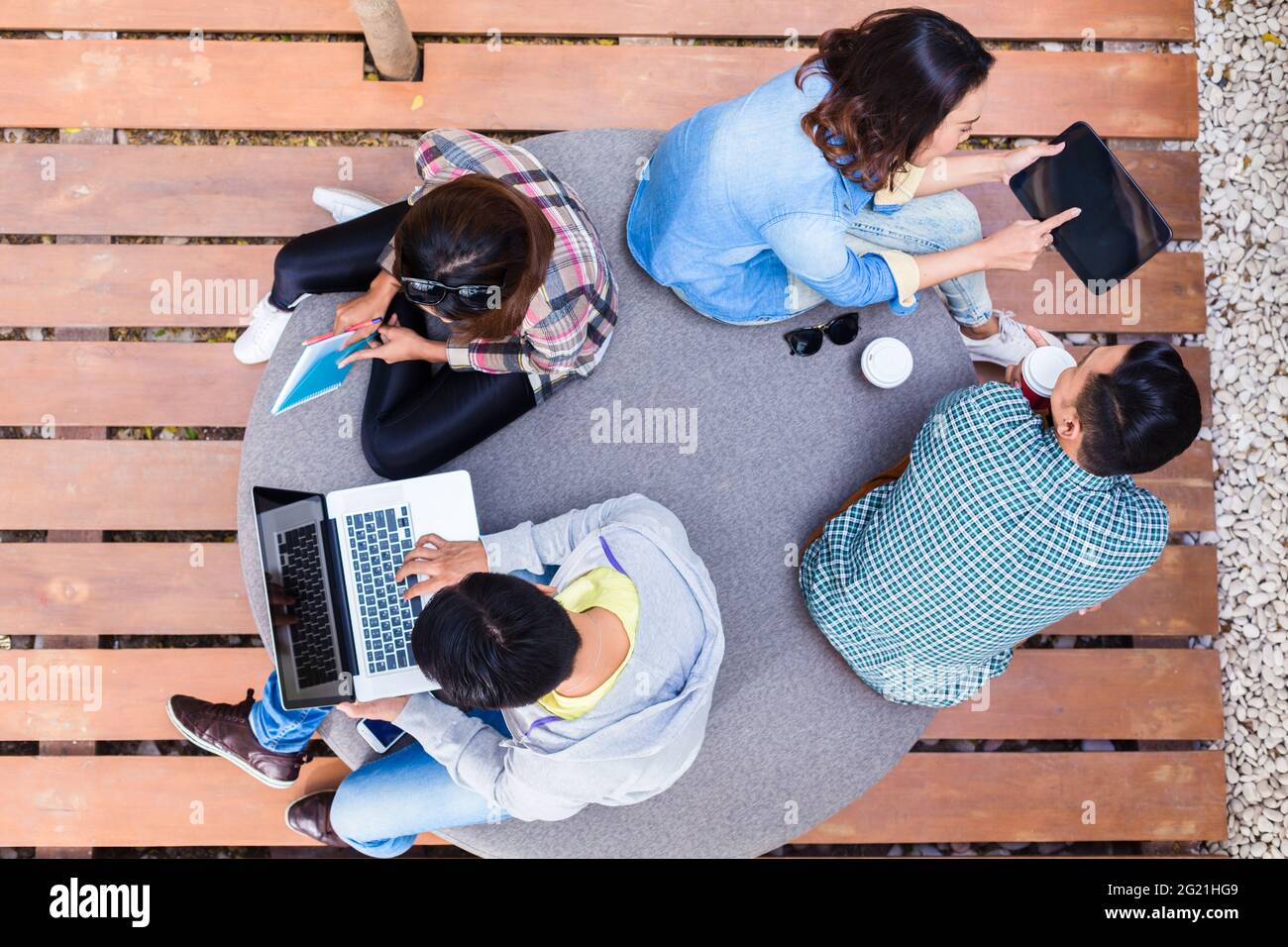 Blick auf vier junge Mitarbeiter mit moderner Funktechnik Technologie bei der Arbeit im Freien an verschiedenen Projekten Stockfoto