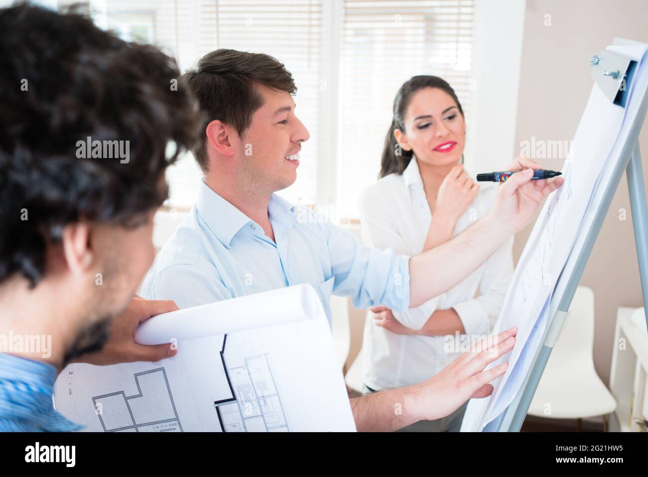 Architekten und Bauingenieure sprechen über die Baupläne für Gebäude am Flipchart Stockfoto