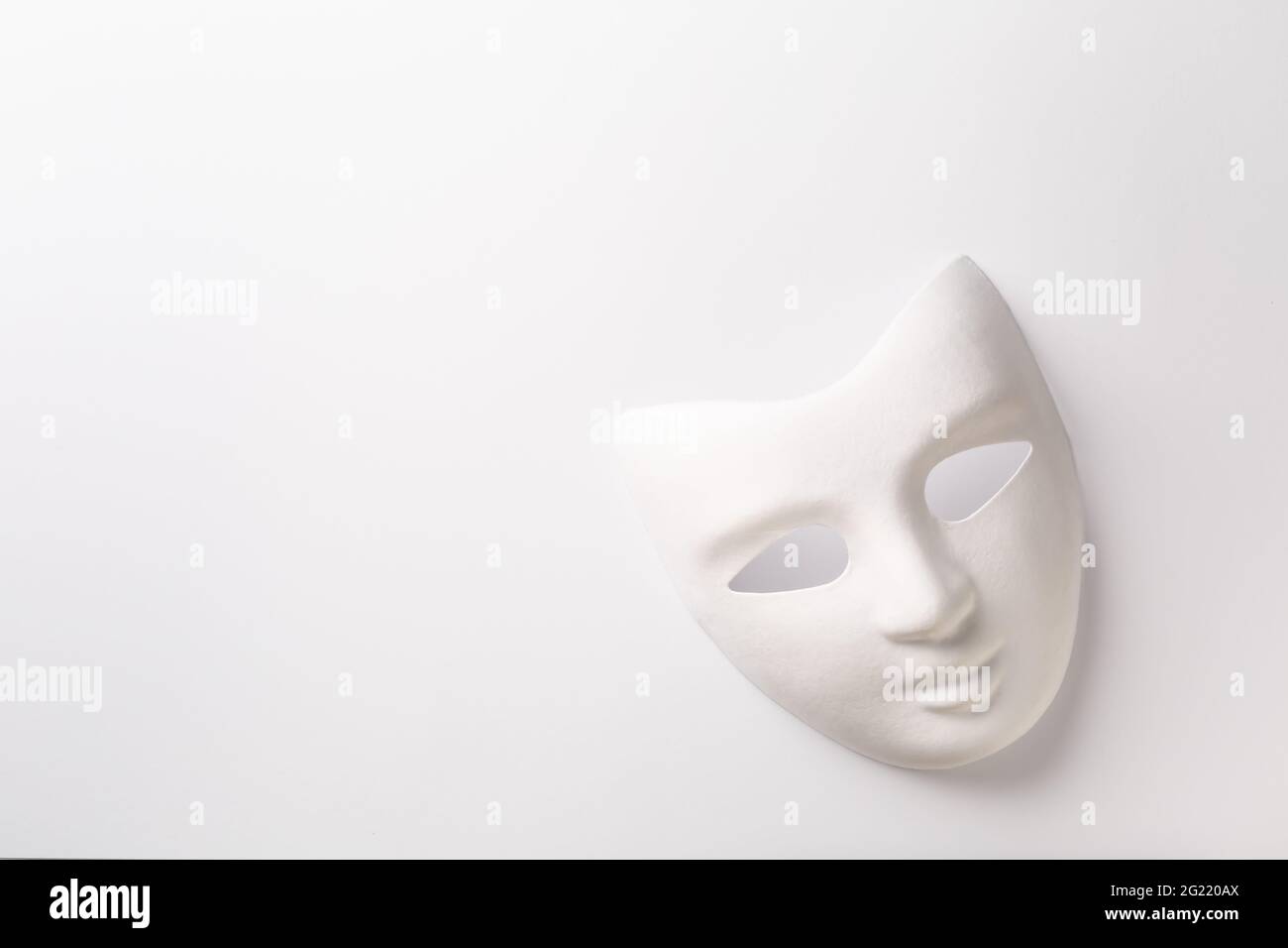 Theater- oder Karnevalskonzept - weiße Maske auf weißem Hintergrund mit Platz für Text Stockfoto