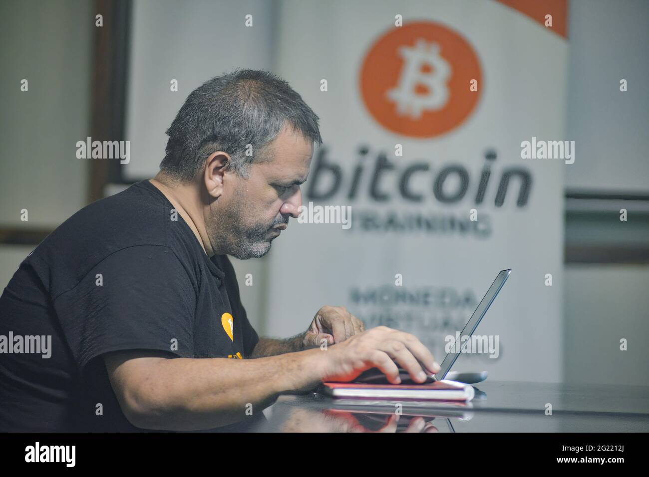 Chiltuipan, El Salvador. Juni 2021. Ein Mann arbeitet an einem Laptop in einer Bitcoin-Trainingseinrichtung. Der salvadorianische Präsident Nayib Bukele hat angekündigt, dass er dem Kongress ein Gesetz vorschlagen wird, in dem seine Partei die Mehrheit kontrolliert, damit Bitcoin zum legalen Zahlungsmittel wird. El Salvador würde das erste Land der Welt werden, das eine Kryptowährung als gesetzliches Zahlungsmittel akzeptiert. Kredit: SOPA Images Limited/Alamy Live Nachrichten Stockfoto