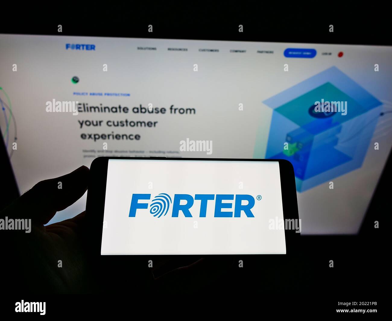 Person, die Mobiltelefon mit dem Logo des Softwareunternehmens Forter Inc. Zur Betrugsbekämpfung auf dem Bildschirm vor der Geschäftswebseite hält. Konzentrieren Sie sich auf die Telefonanzeige. Stockfoto