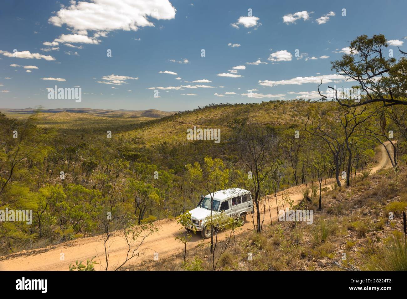 Eine isolierte Feldstraße, die sich durch das malerische Tal zwischen Lapa Junction und Mt Garnet in Queensland, Australien, schlängelt. Stockfoto