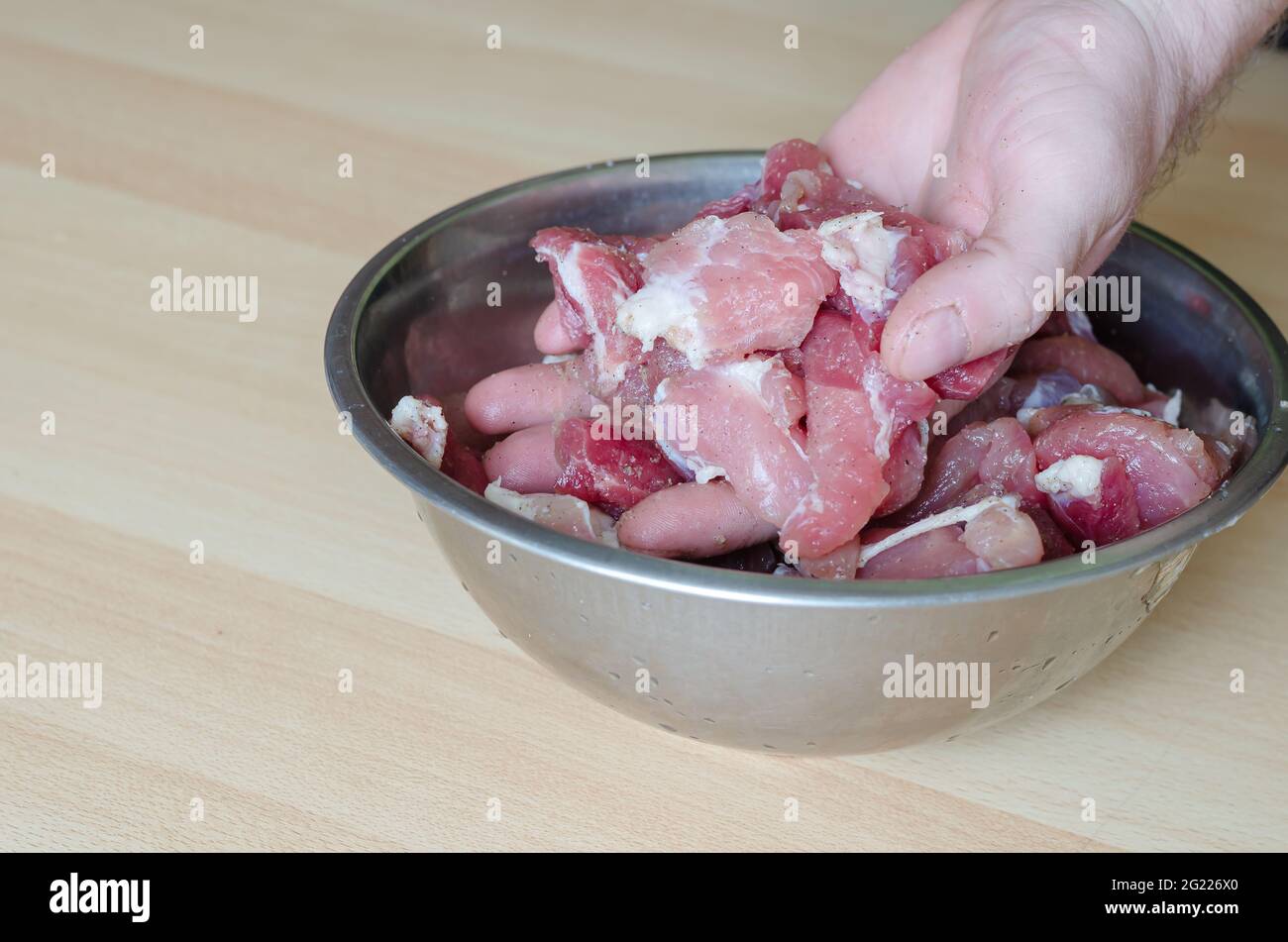 Schritt für Schritt kochen hausgemachten gehackten Schinken. Schritt 2. Das  Fleisch mit den Gewürzen für den Schinken von Hand verrühren. Eine Schüssel  mit Fleischstücken, Salz, Knoblauch und Pfeffer Stockfotografie - Alamy