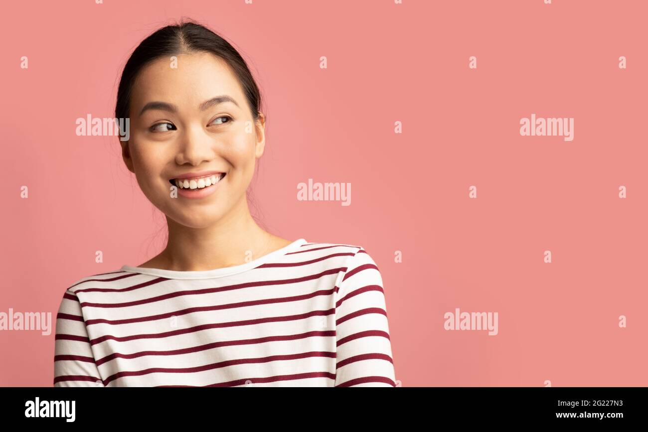 Porträt Einer Interessierten Jungen Asiatischen Frau, Die Mit Aufregung Beiseite Schaut Stockfoto