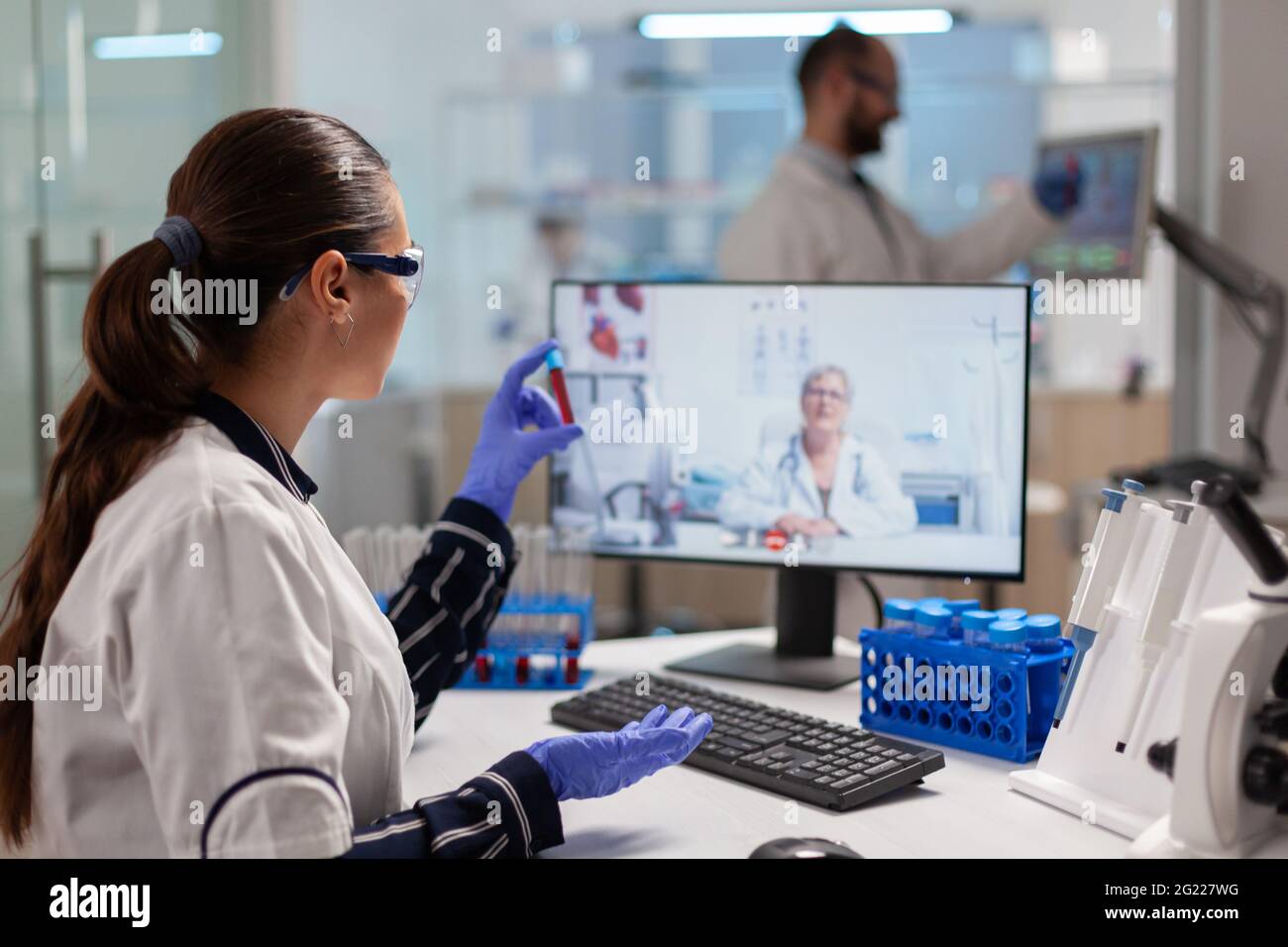 Arzt Arzt bietet medizinische Online-Ratschläge an Forscher halten Blutprobe Rohr mit pc. Chemiker untersucht die Entwicklung von Impfstoffen mithilfe von Hightech-Forschungsmethoden. Stockfoto