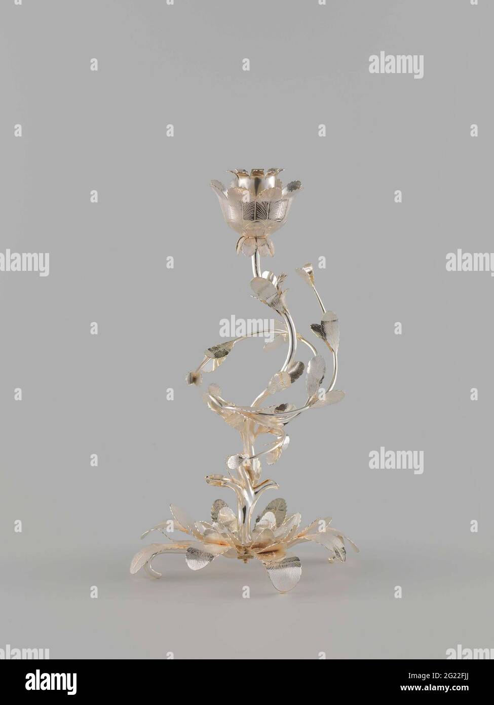 Silberner Kerzenhalter mit Stiel in Form eines aufziehenden Stammes mit drei schwingenden Ästen mit ovalem Blatt und Kerzenhalter in Blumenkranz. Kerzenhalter aus Silber. Aus einer Blattrosette, die sich in drei sich windende Zweige mit ovalen Blättern teilt, erhebt sich ein sich windenden Stamm. Der Kerzenhalter wird in einem Blumenkranz gefangen. Stockfoto Silberner Kerzenhalter mit Stiel in Form eines aufziehenden Stammes mit drei schwingenden Ästen mit ovalem Blatt und Kerzenhalter in Blumenkranz. Kerzenhalter aus Silber. Aus einer Blattrosette, die sich in drei sich windende Zweige mit ovalen Blättern teilt, erhebt sich ein sich windenden Stamm. Der Kerzenhalter wird in einem Blumenkranz gefangen. Stockfoto