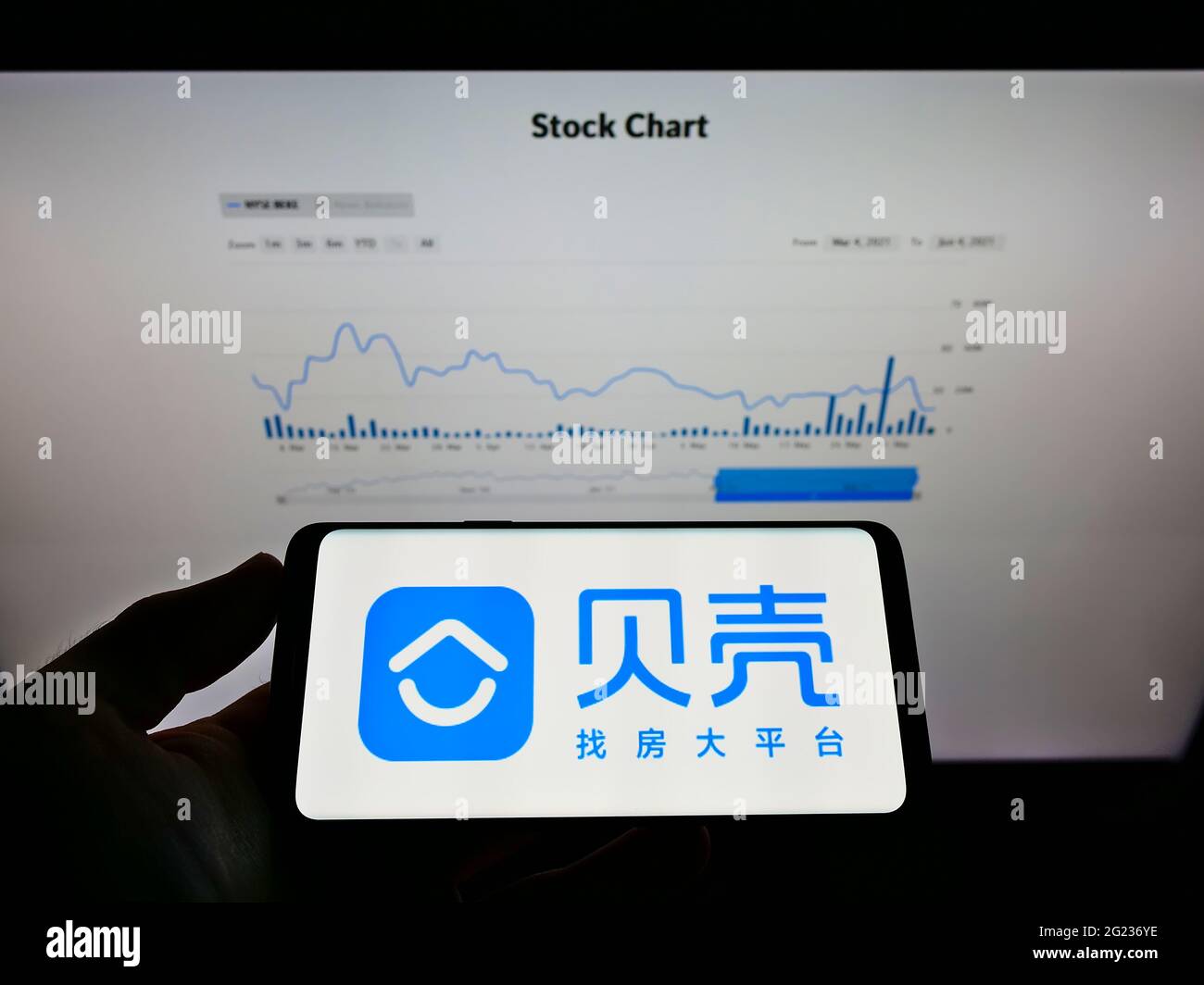 Person, die Mobiltelefon mit dem Logo der chinesischen Immobiliengesellschaft KE Holdings Inc. Auf dem Bildschirm vor der Business-Webseite hält. Konzentrieren Sie sich auf die Telefonanzeige. Stockfoto
