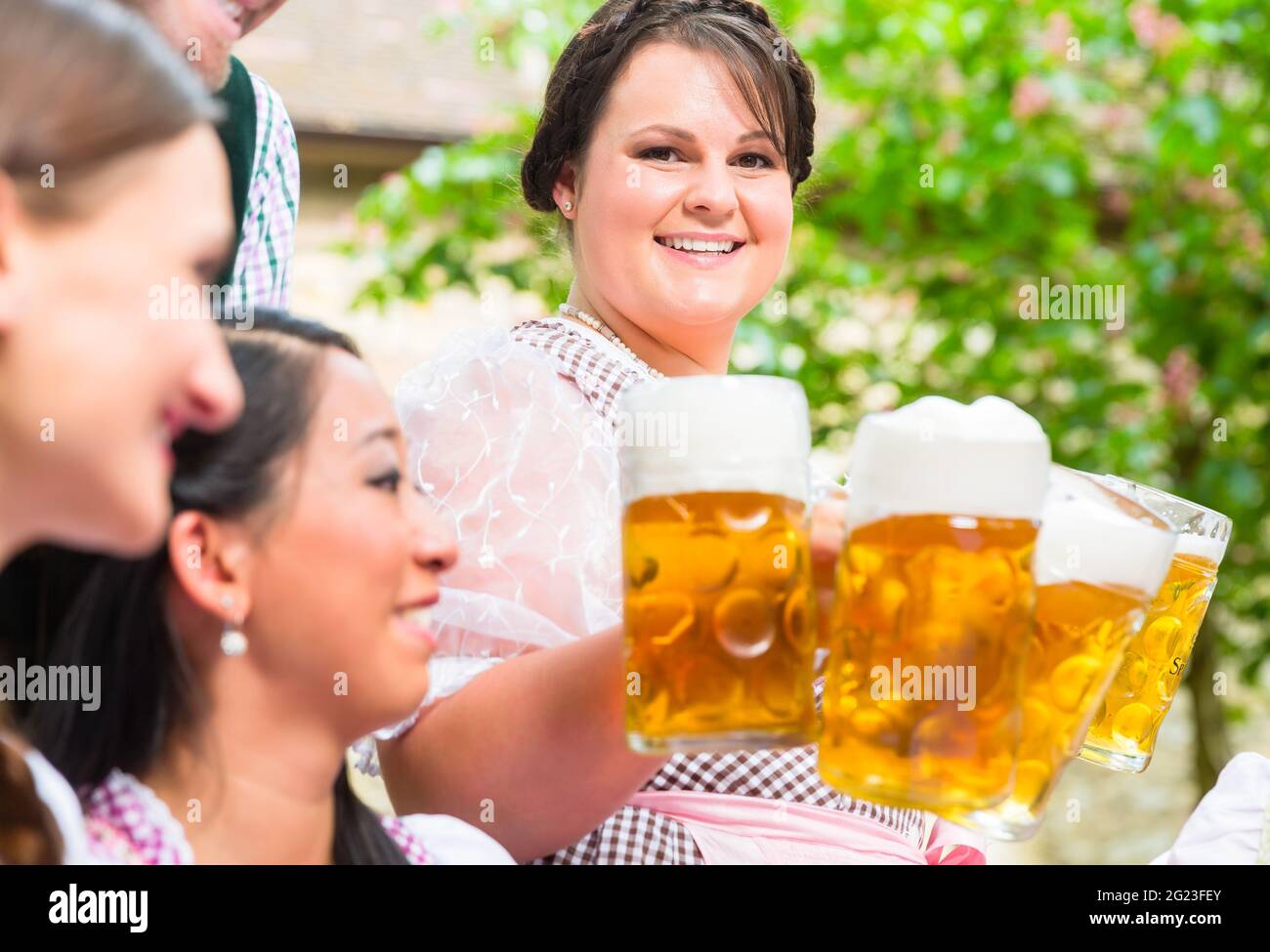 Kellnerin im Biergarten Getränke zu drei Frauen und Männer Stockfoto