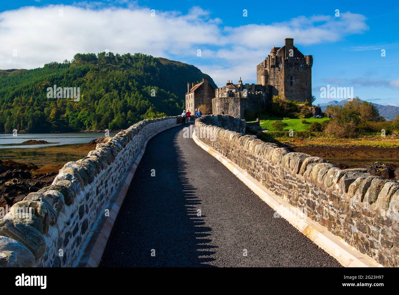 Ein Blick auf den Pfad, der über die Brücke und über das meeresloch zum Eilean Donan Castle in den schottischen Highlands führt. Stockfoto