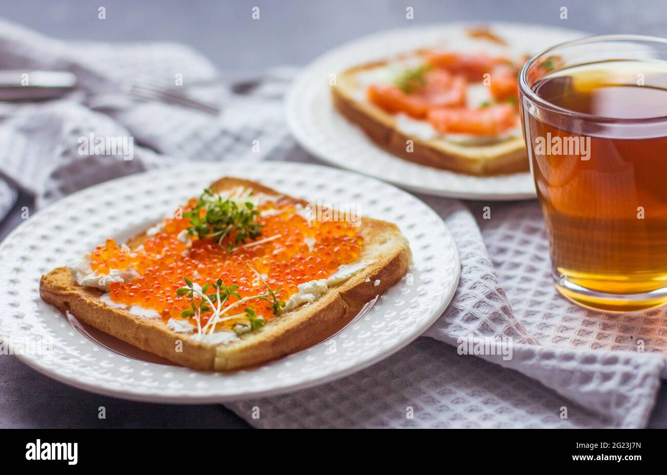 Sandwiches oder Tapas mit Brot, rotem Kaviar und rotem Fisch mit Mikrogemüse, Meeresfrüchten Luxus-Delikatessen Stockfoto