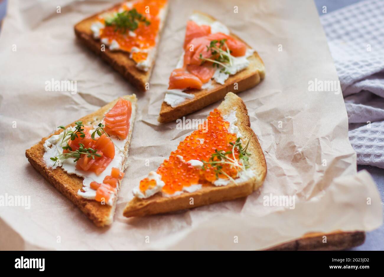 Sandwiches oder Tapas mit Brot, rotem Kaviar und rotem Fisch mit Mikrogemüse, Meeresfrüchten Luxus-Delikatessen Stockfoto