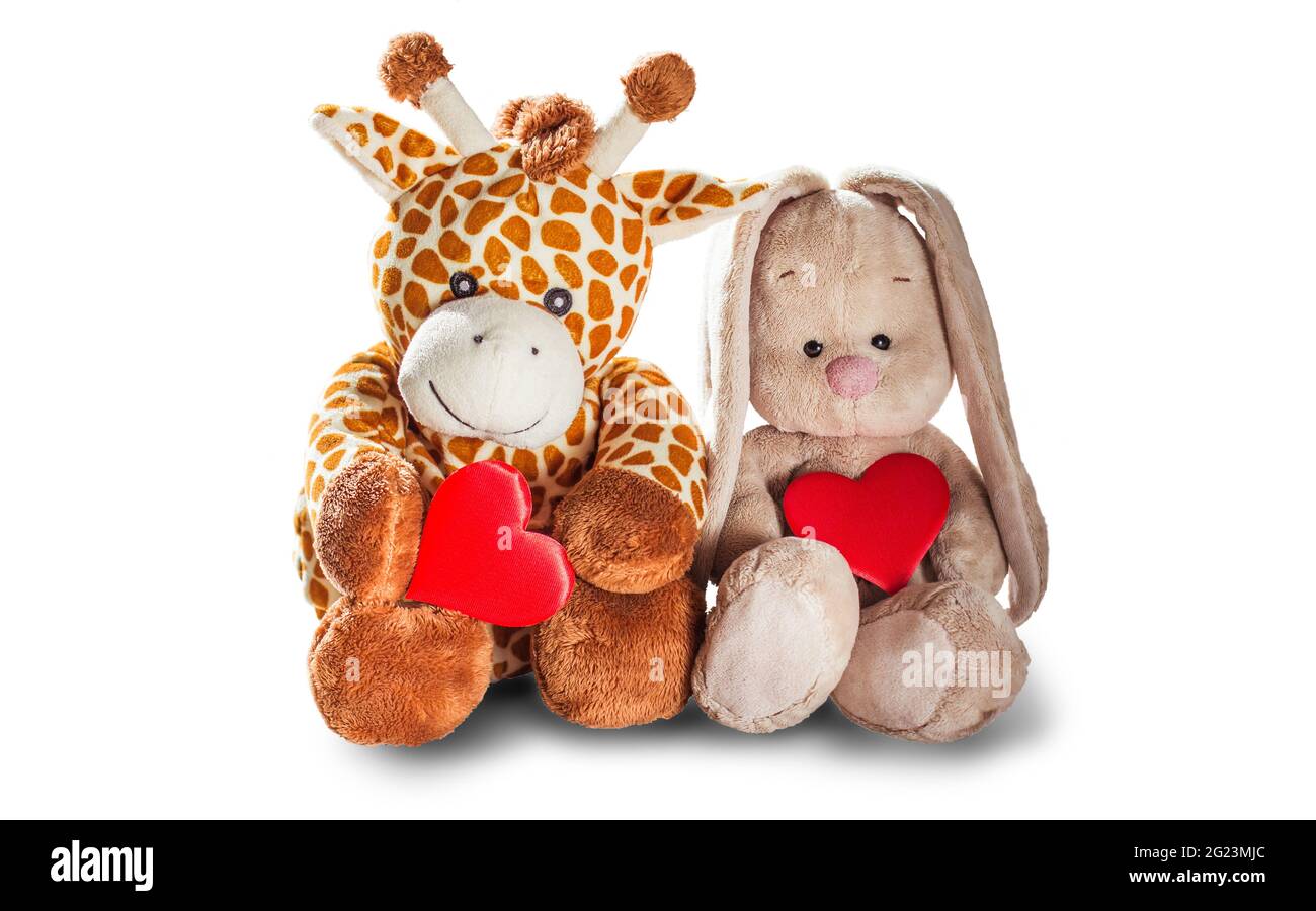 Plüsch Spielzeug Giraffe und Hase Hase halten ein rotes Herz isoliert auf einem weißen Hintergrund bunten Plüsch Spielzeug. Farbige Stofftier-Giraffe und Hase. Weiß und Stockfoto